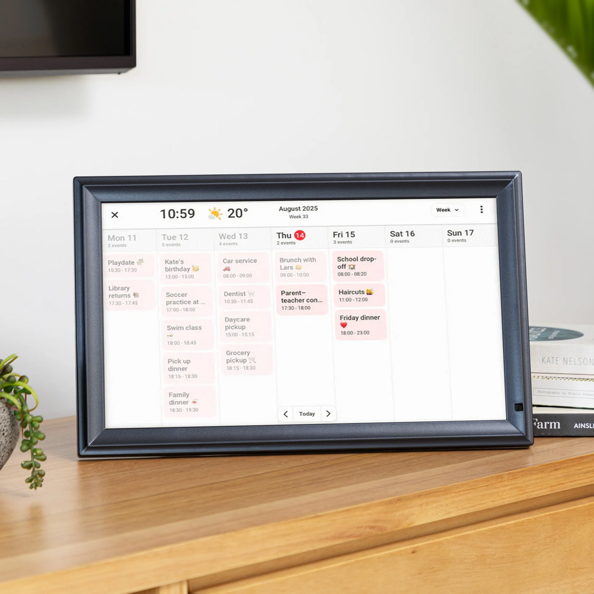 LuvLink Digital Calendar displaying a weekly calendar view with scheduled events on a wooden desk.