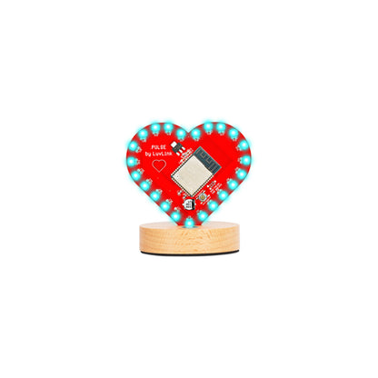 Pulse Lamp features a red heart with turquoise LED lights arranged around the edge, mounted on a natural timber base.