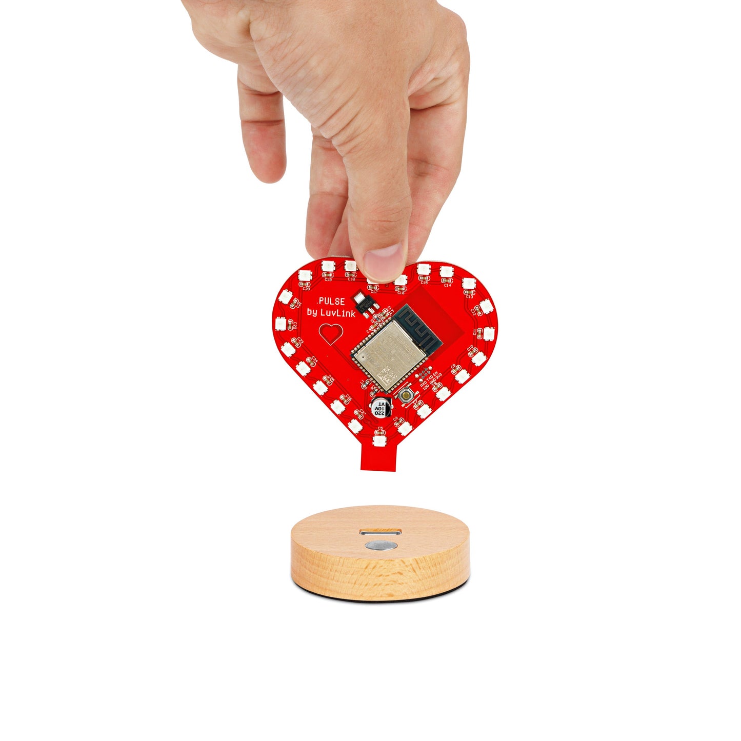 Pulse Lamp's red heart module separating from its natural wooden base during setup.
