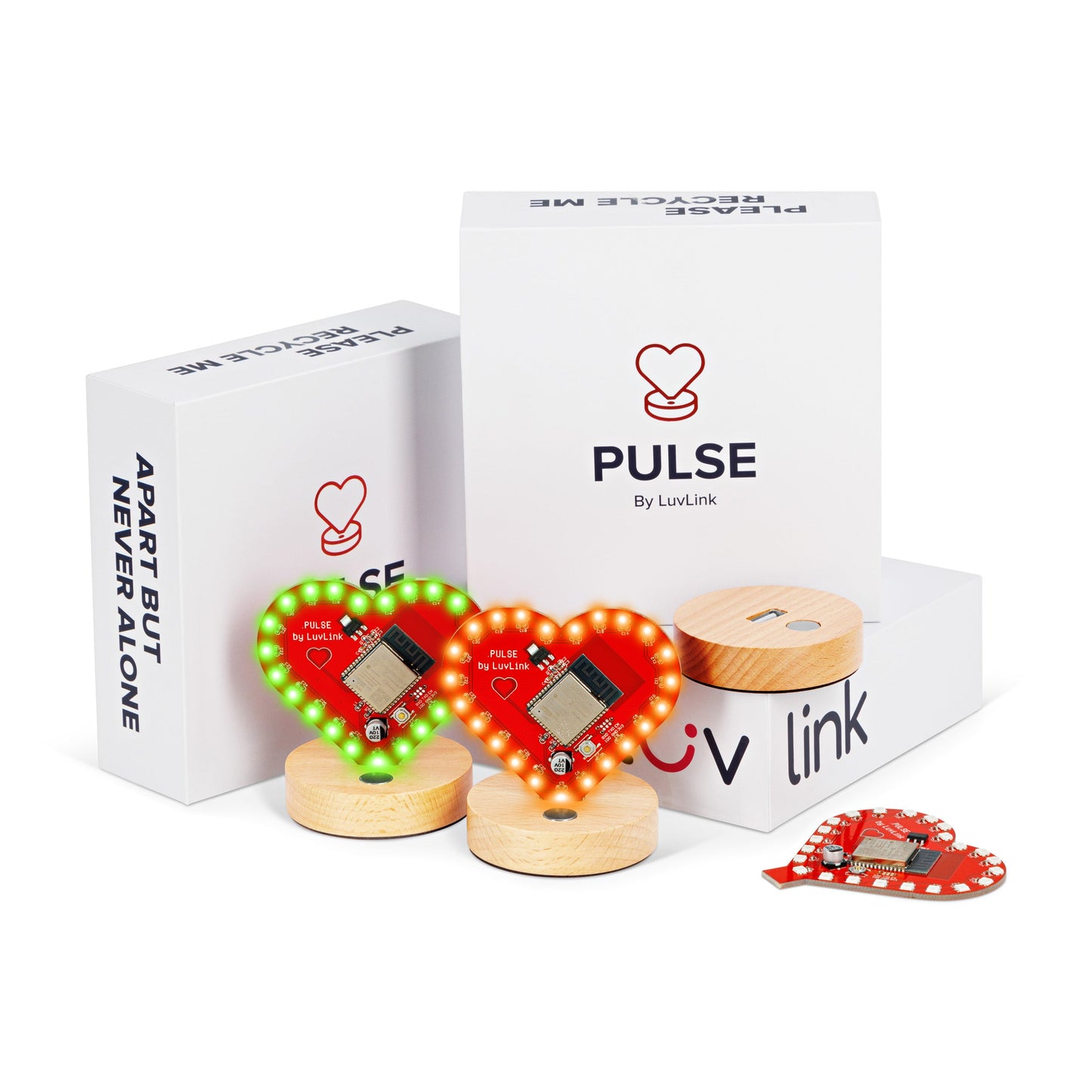 Matching pair of heart-shaped Pulse lamps glowing red and green, displayed with wooden bases, packaging and spare circuit board.