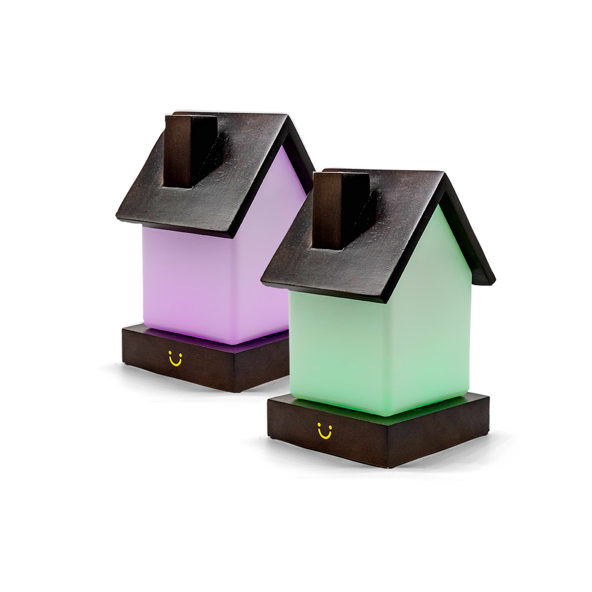 House-shaped lamps glow in soft purple and green with charcoal roofs and timber bases.