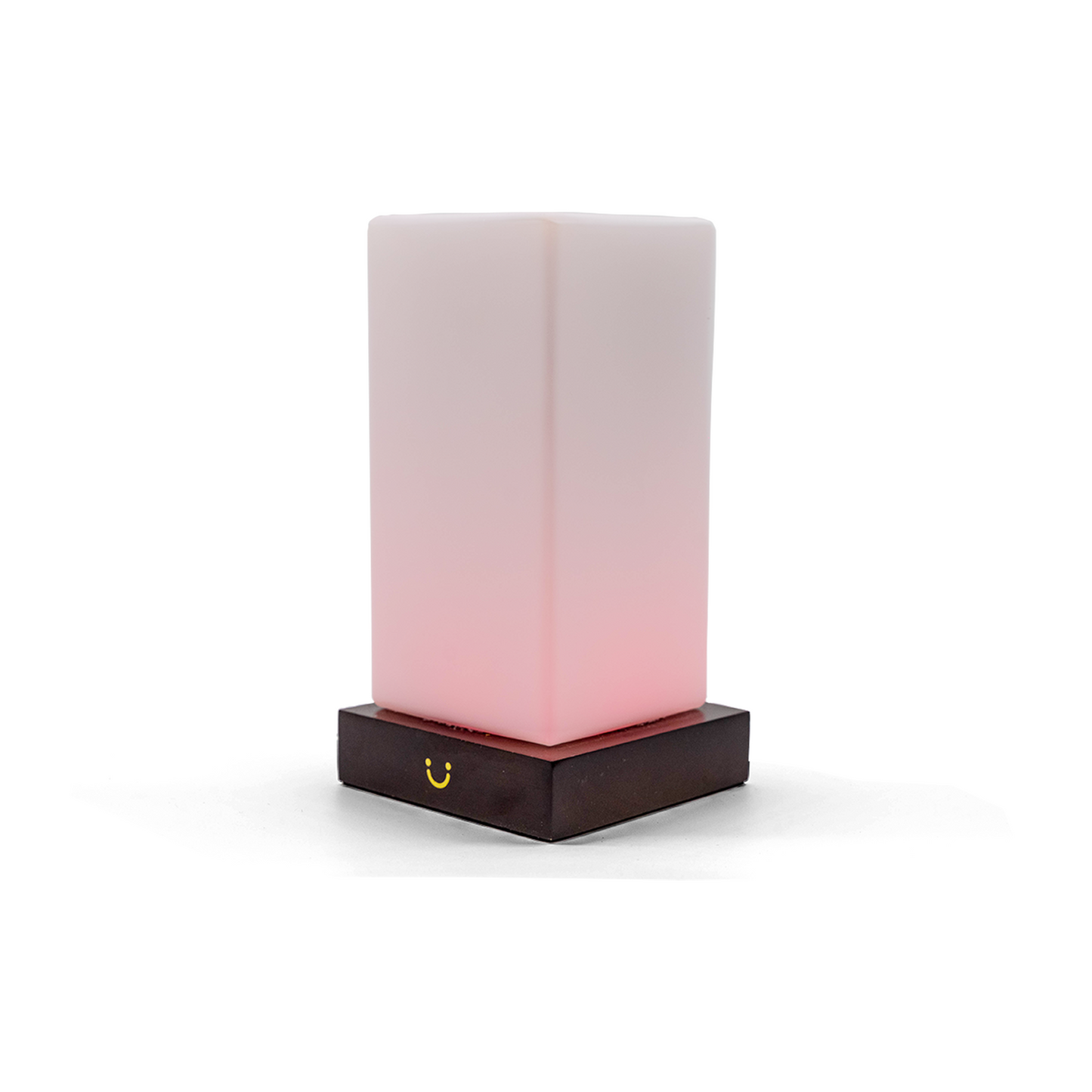 Soft pink tower lamp illuminating from within, mounted on a dark wood base with gold detail.